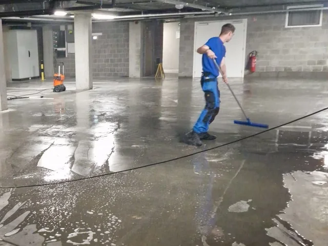 Medewerker reinigt de vloer van een parkeergarage