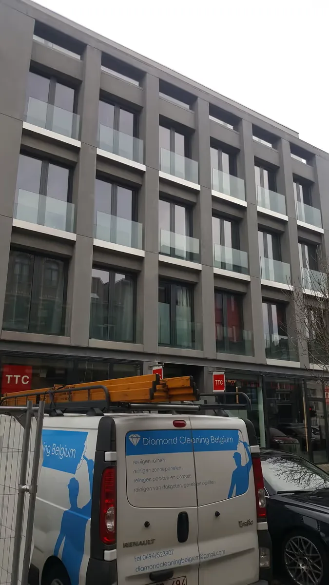 Glasreiniging met een hoogwerker bij een gebouw in Merksem
