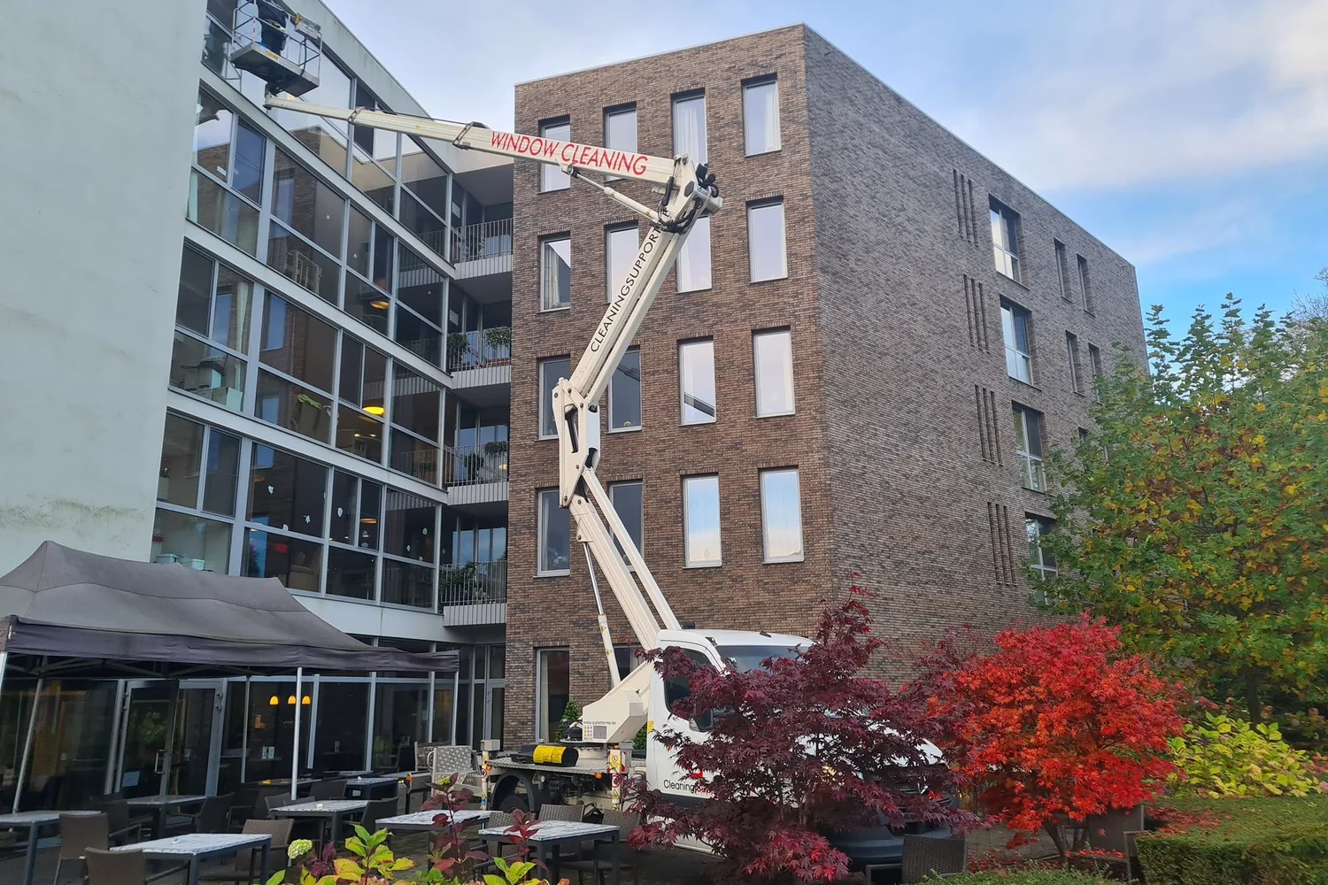 Ramen van een groot gebouw worden met een hoogwerker gereinigd
