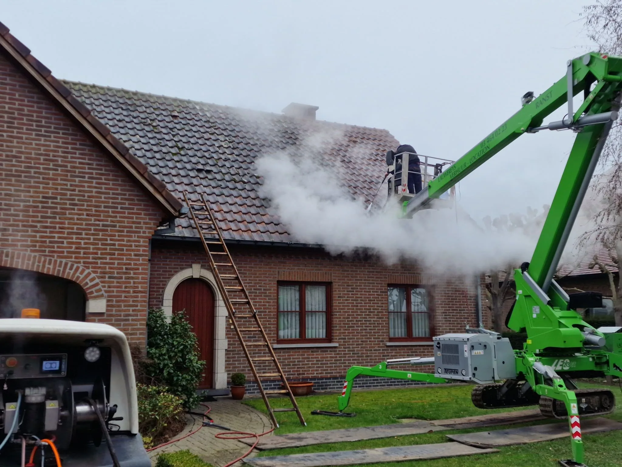 Dakreiniging vanuit een hoogwerker bij een woning