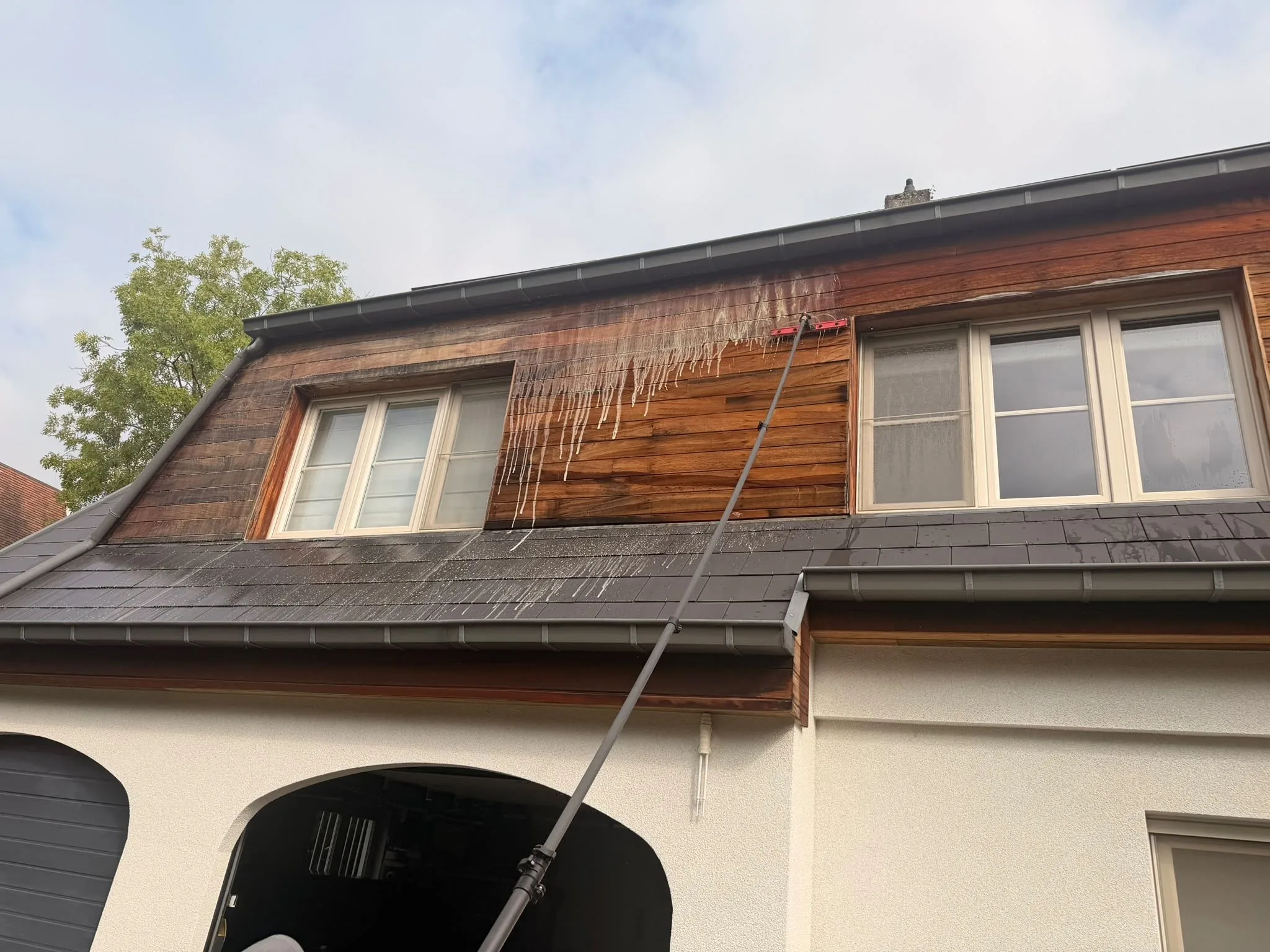 Houten gevelbekleding, gereinigd met de telescoopsteel