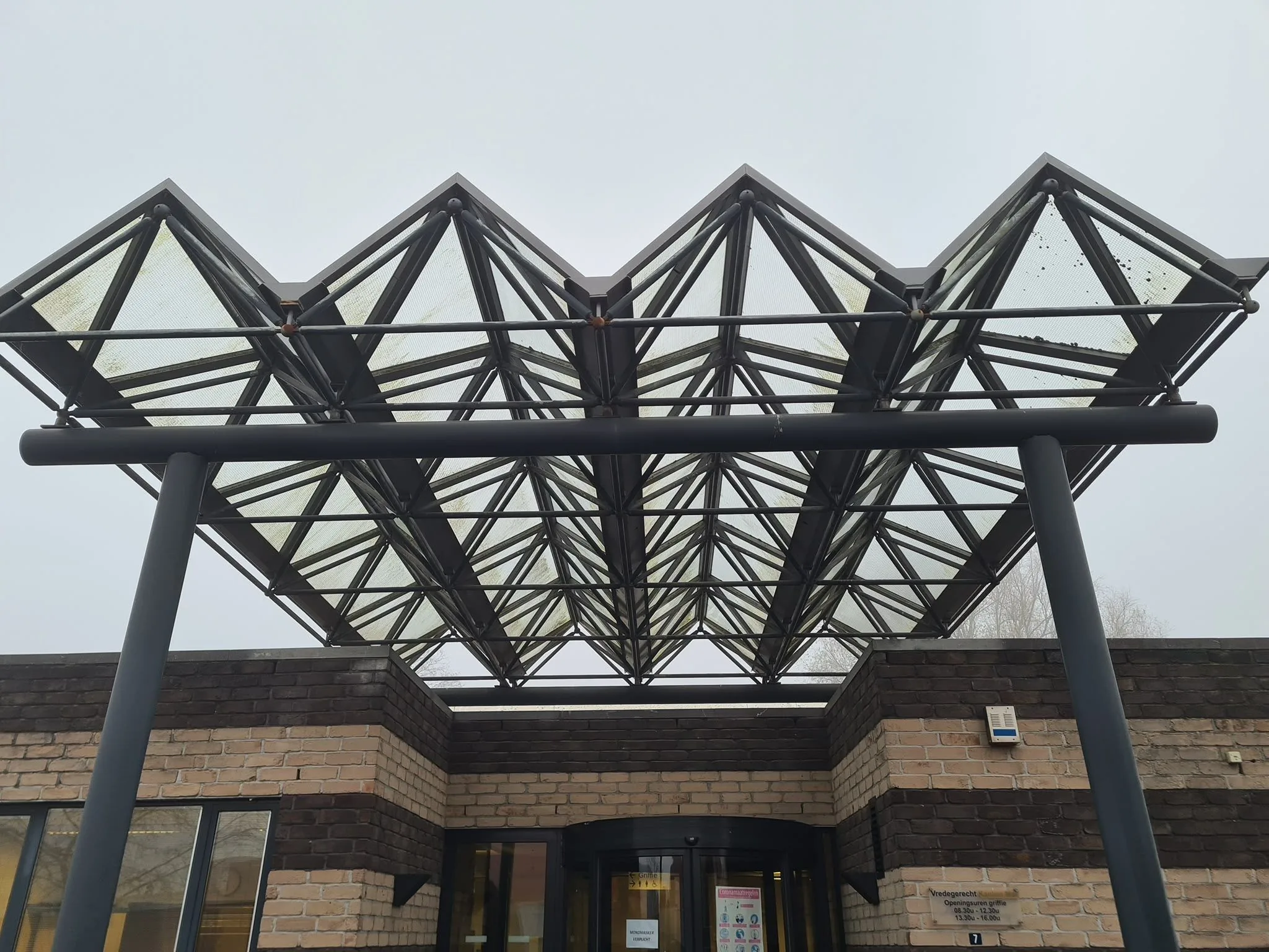 Glazen luifel boven de inkom van een gebouw