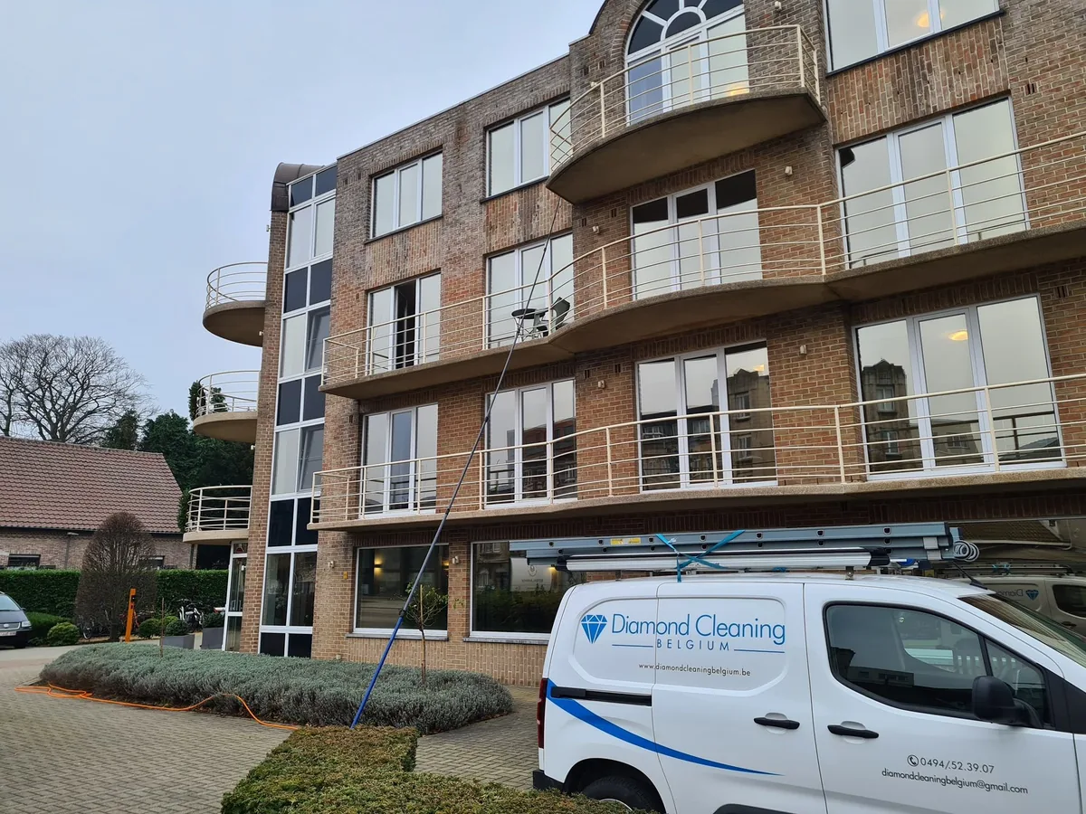 Ramenwas bij een appartementsresidentie, met de bestelwagen ervoor