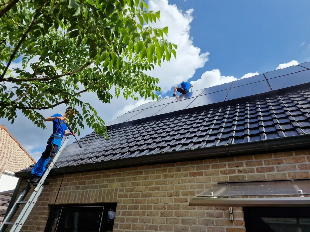 Zonnepanelen op een hellend pannendak worden gereinigd