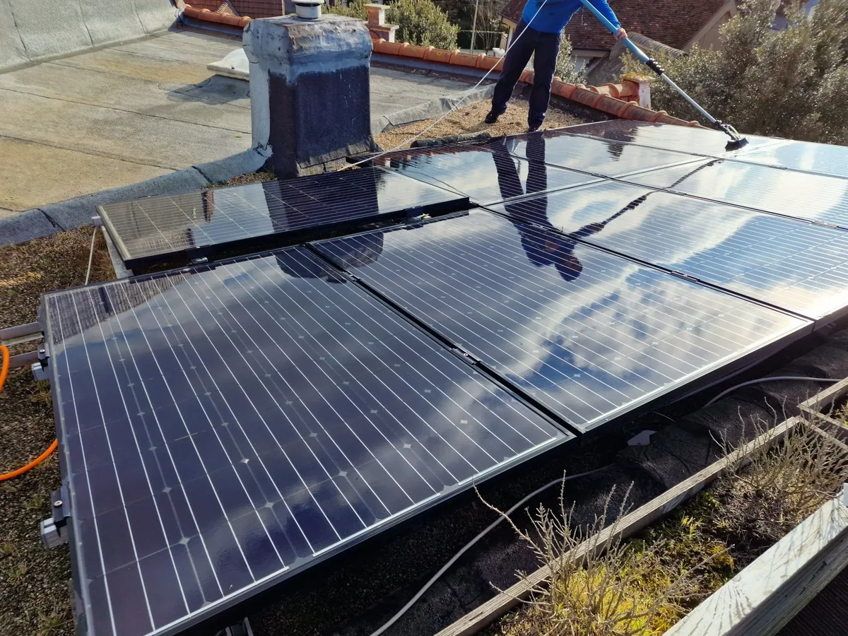 Zonnepanelen op een plat dak, gereinigd met de telescoopborstel