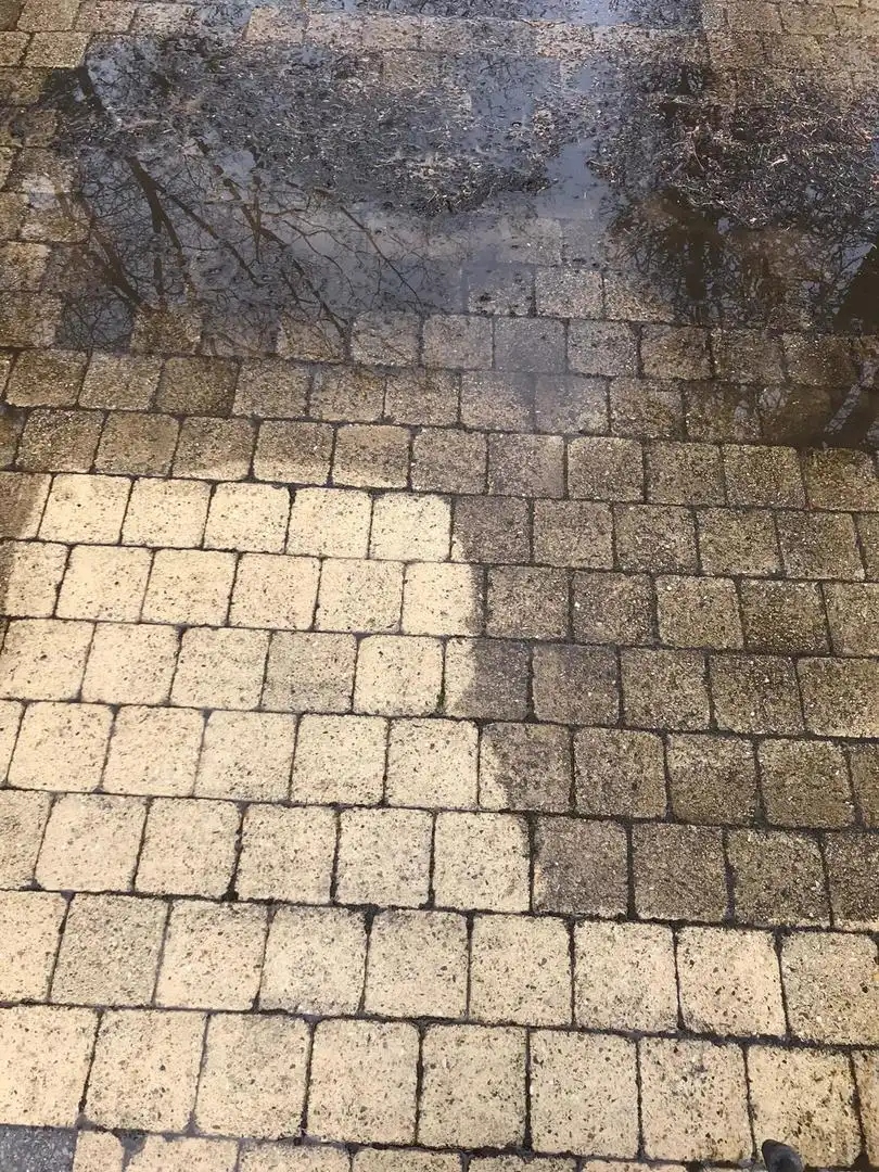 Klinkers van een oprit, het gereinigde stuk naast het vuile